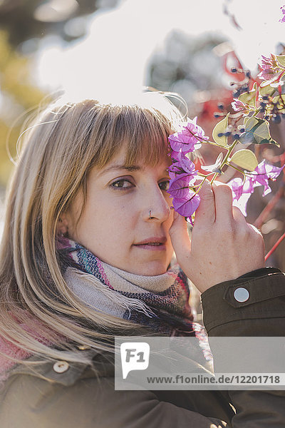 Portrait of woman smelling flowers outdoors