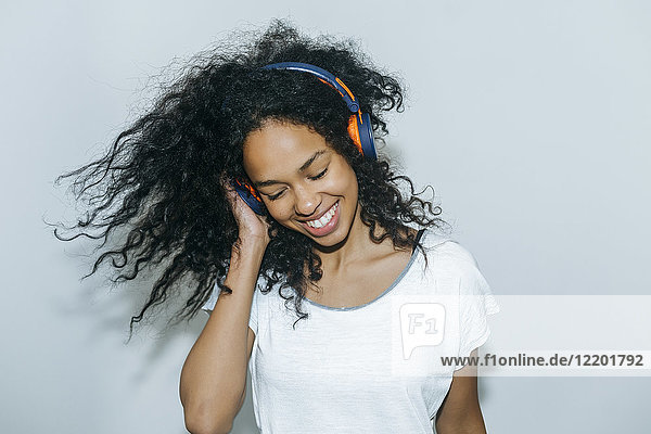 Portrait of happy young woman listening music with headphones