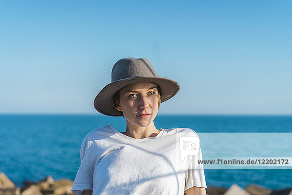 Porträt einer Frau mit Hut vor dem Meer