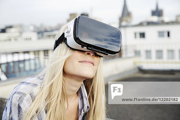 Porträt einer Frau mit Virtual Reality Brille im Freien