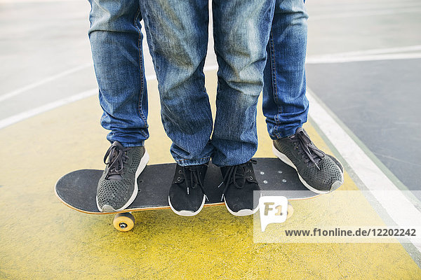 Beine von Erwachsenen und Kindern auf dem Skateboard