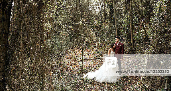 Braut und Bräutigam im Wald stehend