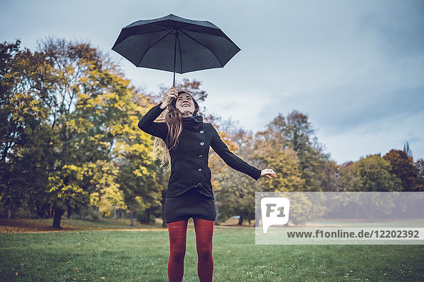Junge Frau mit Schirm im Herbstpark
