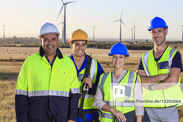 Portrait of four smiling engineers on a wind farm