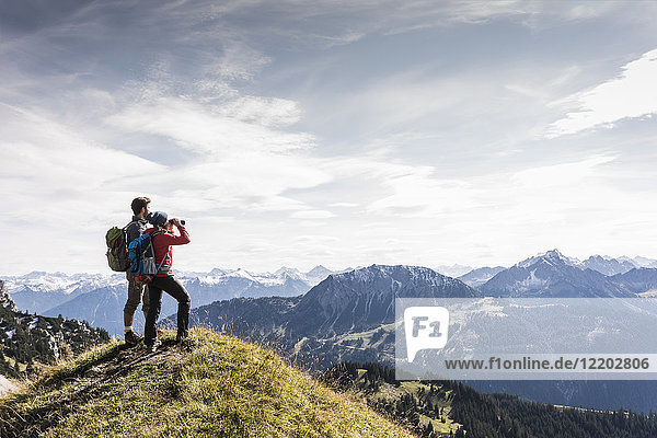 Austria  Tyrol  young couple standing in mountainscape looking at view