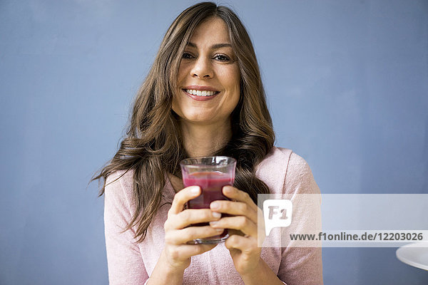 Porträt einer lächelnden Frau mit einem Glas Saft
