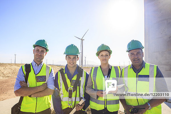 Porträt von vier lächelnden Ingenieuren auf einem Windpark