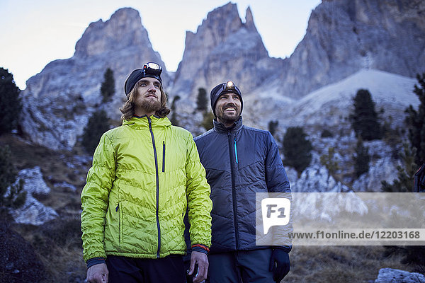 Two confident men wearing headlamps in the mountains