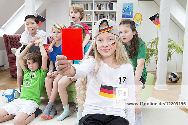 Girl showing red card in front of friends  watching football world cup