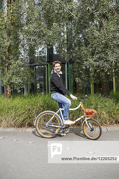 Portrait of smiling man with bicycle on a lane