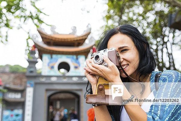Vietnam  Hanoi  junge Frau beim Fotografieren mit altmodischer Kamera