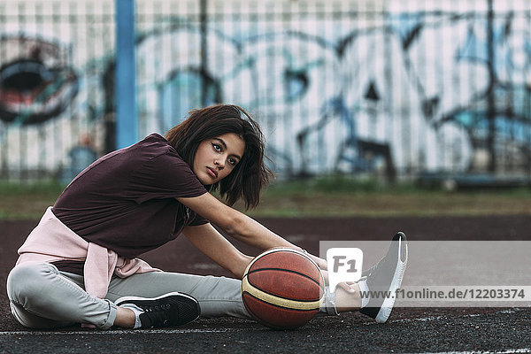 Junge Frau mit Basketball auf dem Freigelände