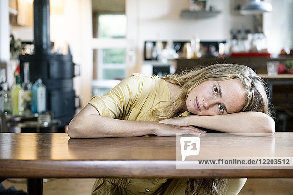 Porträt einer blonden Frau auf dem Tisch liegend