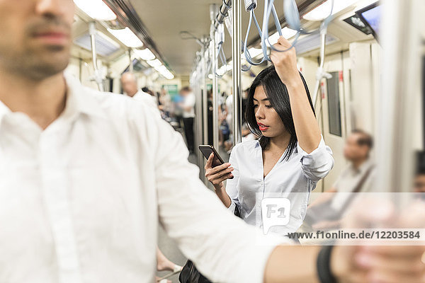 Businesswoman using cell phone in the subway