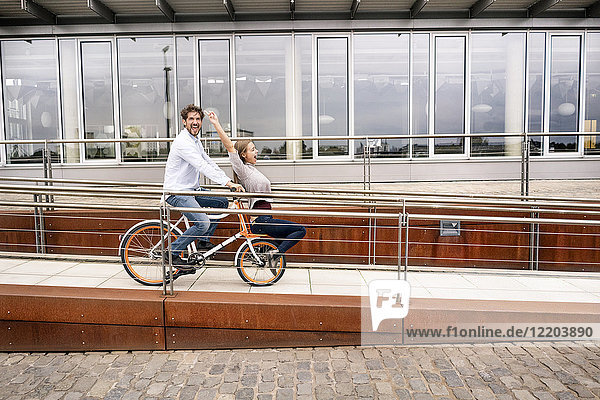 Carefree couple riding bicycle in the city