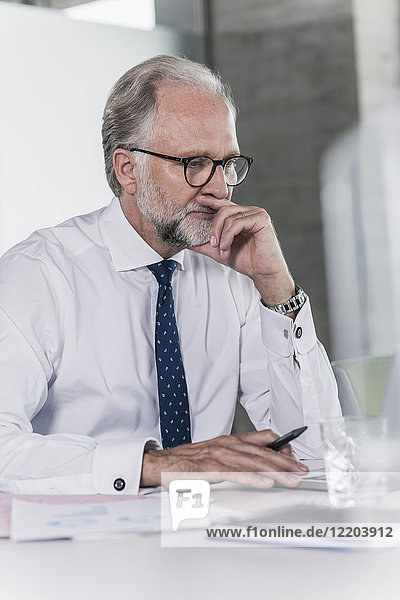 Mature businessman working at desk in office