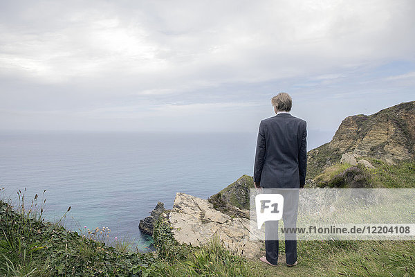 UK  Cornwall  Gwithian  businessman standing at the coast looking at view