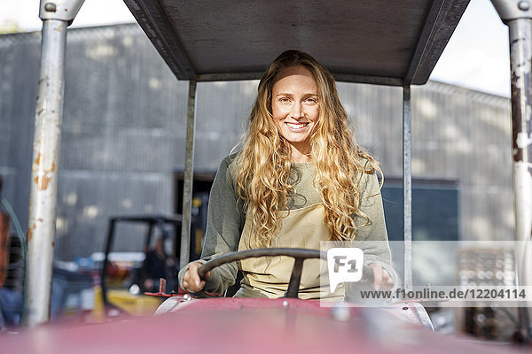 Portrait of smiling woman driving a tractor