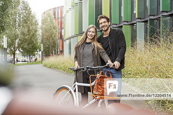 Porträt eines lächelnden Paares mit Fahrrad auf einem Weg