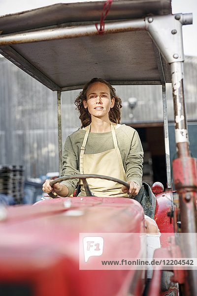 Portrait of confident woman driving a tractor