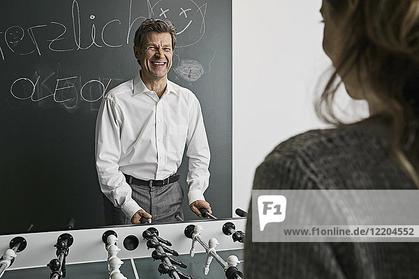 Businessman playing foosball with female colleague