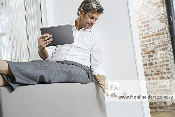 Businessman plugging in tablet