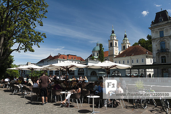 Straßencafés entlang des Flusses Ljubljanica und die Kathedrale des Heiligen Nikolaus im Hintergrund  Ljubljana  Slowenien  Europa