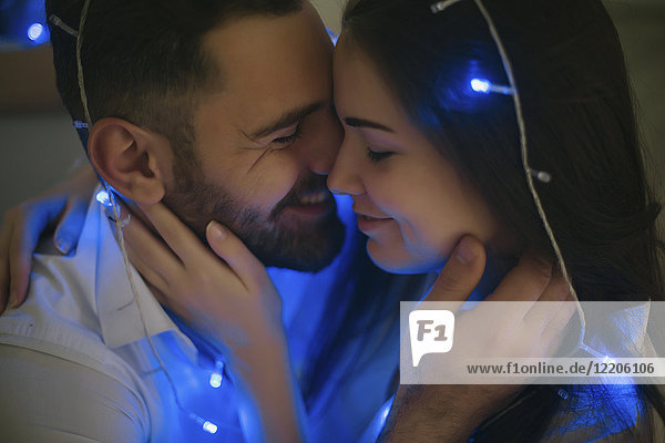 String lights on embracing Caucasian couple