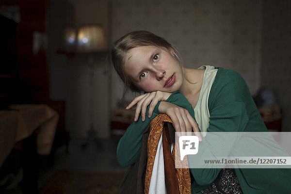 Portrait of pensive Caucasian woman leaning on chair