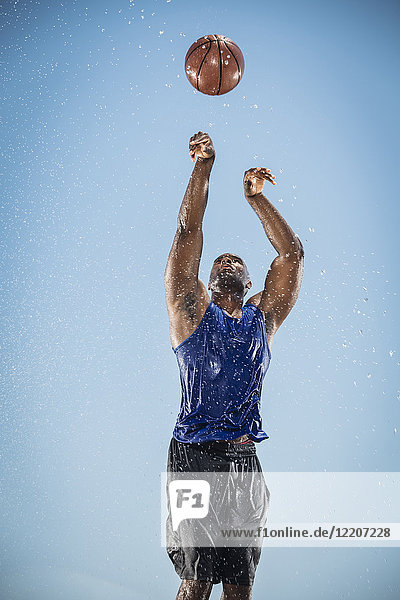 Water splashing on Black man shooting basketball