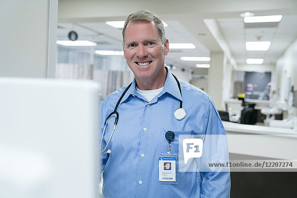 Portrait of smiling doctor using computer in hospital