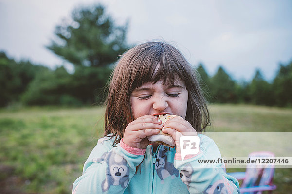 Junges Mädchen  im Freien  isst s'more  Nahaufnahme