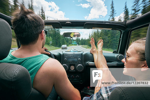 Young woman with feet up driving on road trip with boyfriend  Breckenridge  Colorado  USA