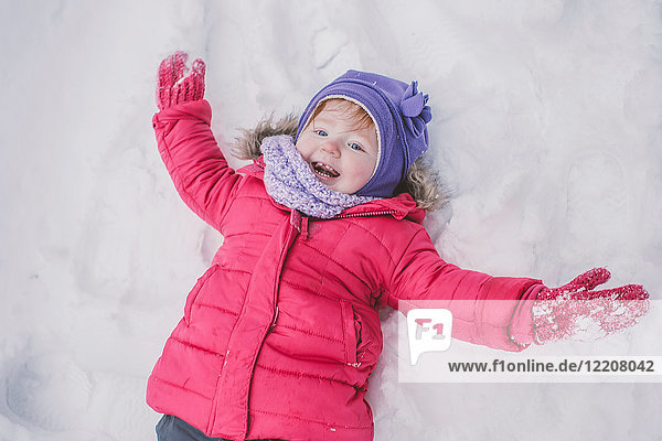 Young girl making snow angel in snow  close-up