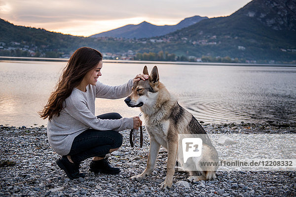 Junge Frau streichelt Hund am Flussufer  Vercurago  Lombardei  Italien