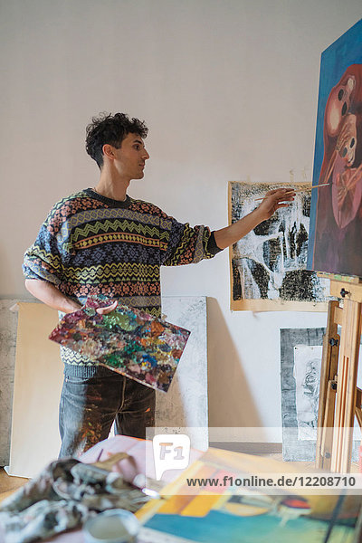 Männlicher Künstler malt Leinwand im Künstleratelier