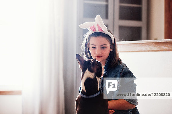 Mädchen sitzend mit Hund  drinnen  Mädchen mit Osterhasenohren