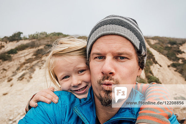 Portrait of father and son outdoors smiling close-up