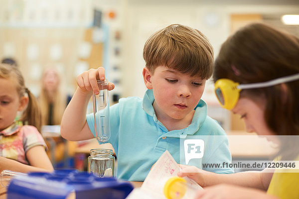Grundschüler und Mädchen beim Reagenzglasexperiment im Klassenzimmer