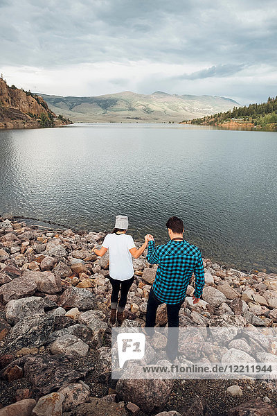 Couple walking on rocks beside Dillon Reservoir  elevated view  Silverthorne  Colorado  USA