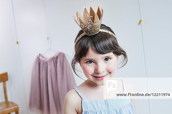 Portrait of young girl wearing crown headband  smiling