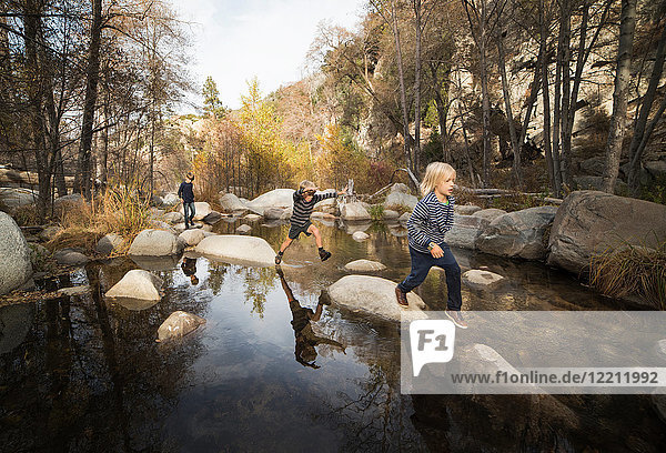 Kinder spielen auf Felsen im Fluss  Lake Arrowhead  Kalifornien  USA