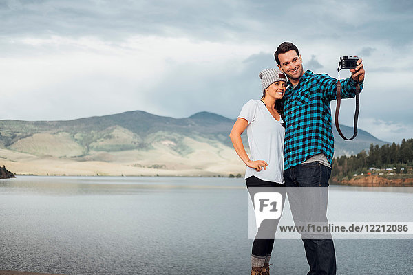 Couple beside Dillon Reservoir  taking selfie  using camera  Silverthorne  Colorado  USA