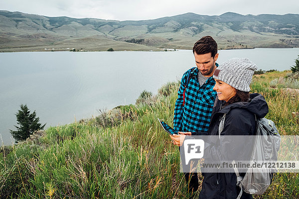 Couple standing beside Dillon Reservoir  using digital tablet  Silverthorne  Colorado  USA