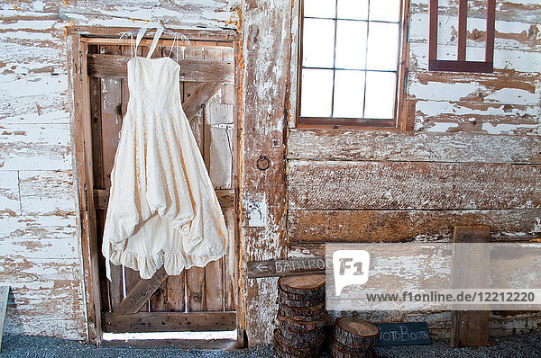 Vintage wedding dress hanging on barn door