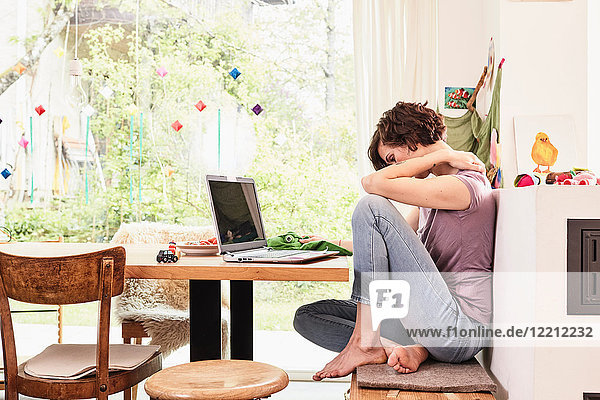 Mittlere erwachsene Frau zu Hause  die einen Laptop benutzt  besorgter Ausdruck