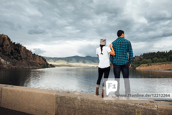 Couple standing on wall beside Dillon Reservoir  looking at view  rear view  Silverthorne  Colorado  USA