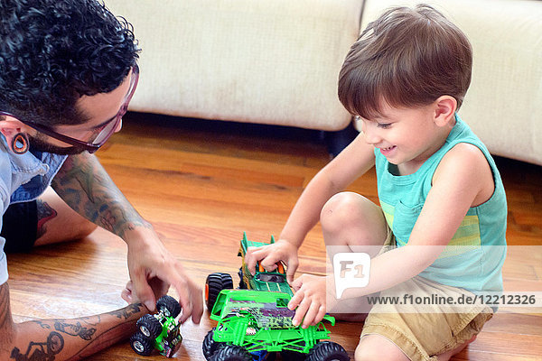 Mann beobachtet Sohn beim Spielen mit Spielzeug