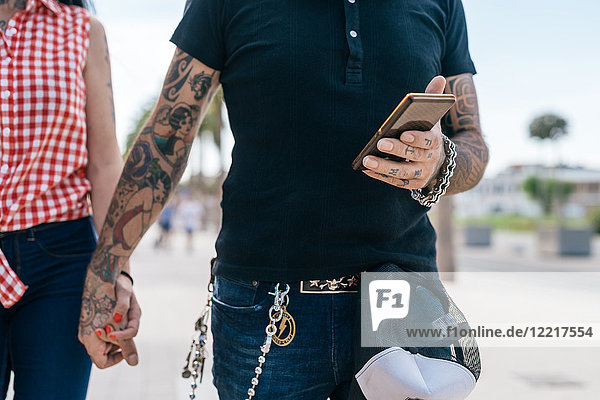 Tätowiertes Hipster-Pärchen  das Hände und Smartphone hält  Mittelteil