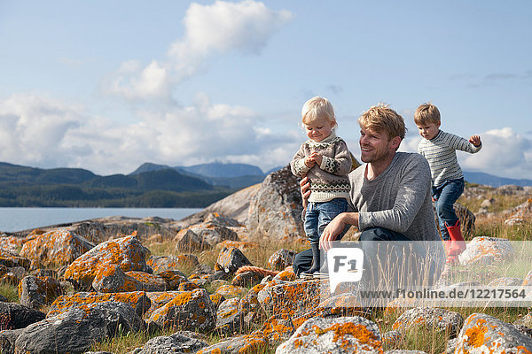 Man with sons playing by fjord  Aure  More og Romsdal  Norway